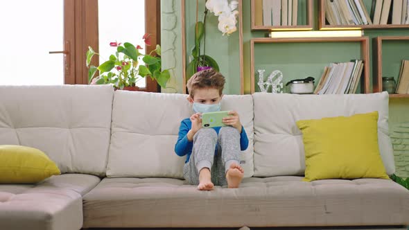 Concentrated Small Boy Using a Smartphone To Play