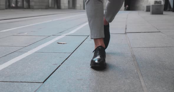 Business Man Feet in Expensive Shoes Walking on Concrete Plates