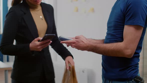 Close Up of Businesswoman Paying Takeaway Food Lunch Order with Smartphone Using POS