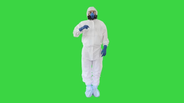 Doctor Wearing Hazard Suit Pointing with Finger Up Wanting Your Attention on a Green Screen, Chroma