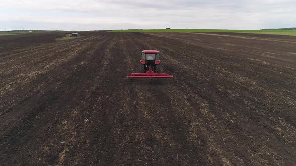 04. Tractor with Disc Harrows on the Farmland. Summer, cloudy