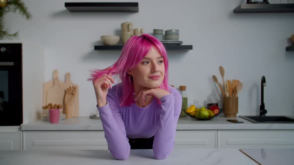 Portrait of Dreamy Lovely Pink Haired Young Woman Smiling in Kitchen
