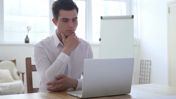 Pensive Businessman Thinking and Working on Laptop