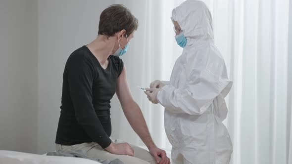 Middle Shot of Professional Doctor Vaccinating Patient in Hospital Ward