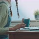 Caucasian young woman using a laptop while holiding a cup - VideoHive Item for Sale