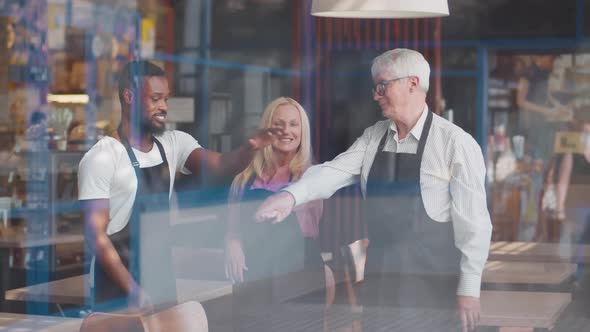 View Through Window of Mixedrace Coffee Shop Staff Put Hands Together