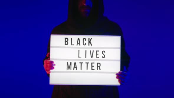 Dramatic Man in Hood Hold Black Lives Matter Sign