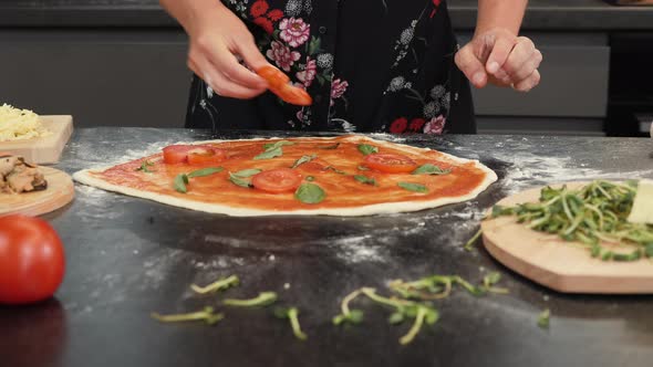 Cooking pizza. Woman chef making italian pizza Margherita using traditional recipe.