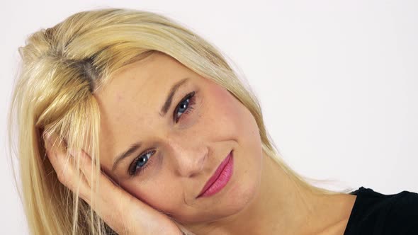 A Young Attractive Woman Smiles at the Camera with Her Head Propped on Her Hand - White Screen