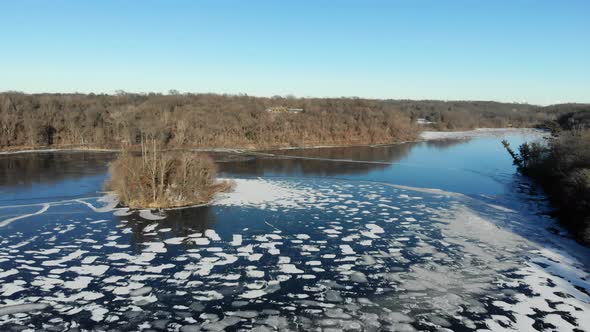 Aerial video over a beautiful half frozen lake in the heart of rural America