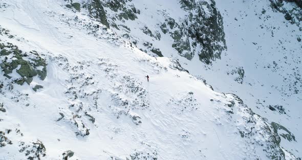 Side Aerial Over Winter Snowy Mountain with Mountaineering Skier People Walking Up Climbing