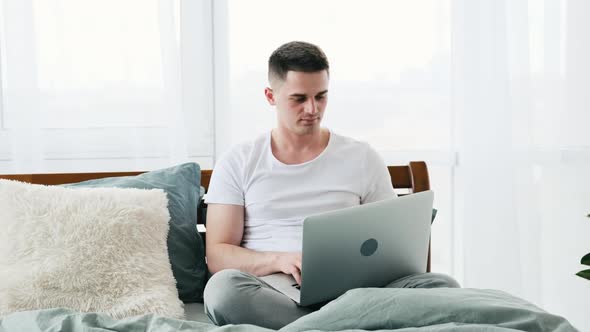 Man with Laptop in the Bed