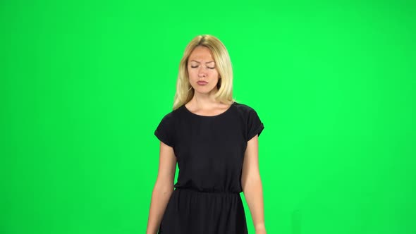 Pensive Girl Is Walking on a Green Screen at Studio
