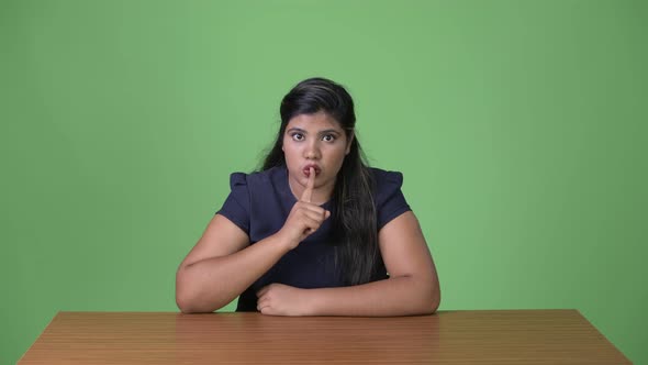 Young Overweight Beautiful Indian Businesswoman Against Green Background