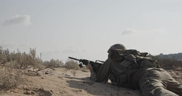 Soldier running on a sand hill during combat, under fire