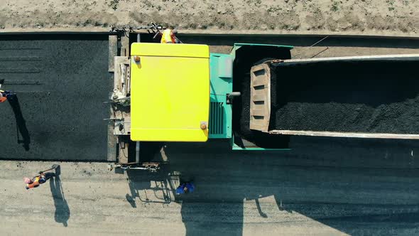 Road Workers Are Laying Bitum on the Fresh Road. Asphalt Paver Machine on a Road Construction Site.