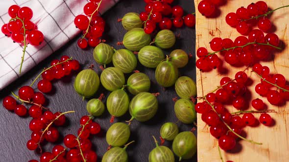 Delicious Red Cranberry and Juicy Green Gooseberry on a Black Stone Table