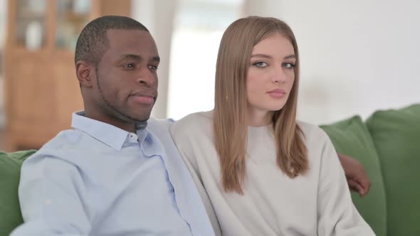 Attractive Mixed Race Couple Sitting and Looking at Camera