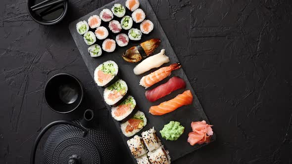 Assortment of Different Kinds of Sushi Rolls Placed on Black Stone Board