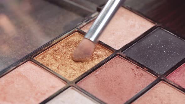 Close Up of Make Up Brush and Eyeshadows Palette on Vanity Table