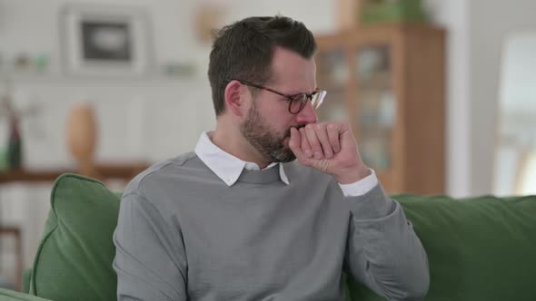 Middle Aged Man Coughing While Sitting on Sofa