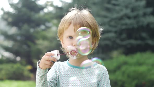 Beautiful Little Girl with Soap Bubbles. Slow Motion. Close Up