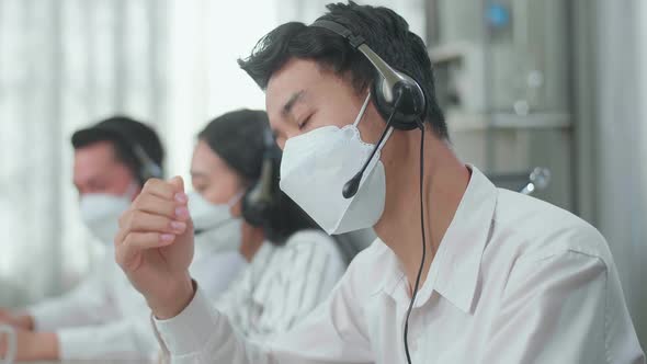 Man Of Three Asian Call Centre Agents In Mask Headache Because His Colleagues Are Talking