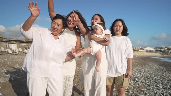 Group of Multigenerational Asian Women and Baby Girl Waving in Slow Motion Smiling Standing on