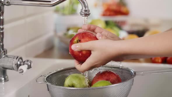 Handheld view of woman washing seasonal fresh apples