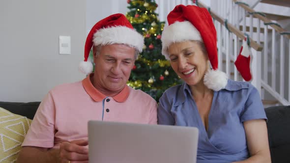 Animation of happy caucasian senior couple having video call at christmas time