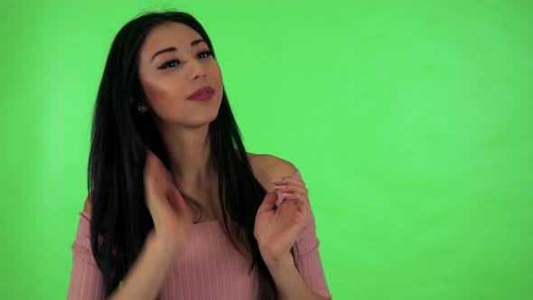 Young Attractive Asian Woman Adjusts Her Clothes and Smiles To Camera - Green Screen Studio