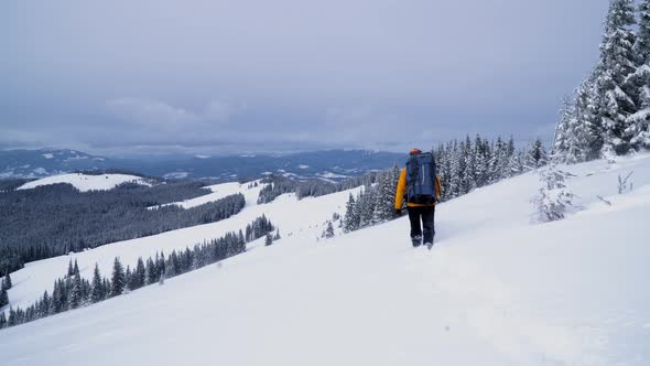 A Tourist Walks Through the Snow in the Mountains.