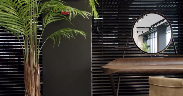 Modern wooden boudoir table with minimalist round mirror with room flowers.