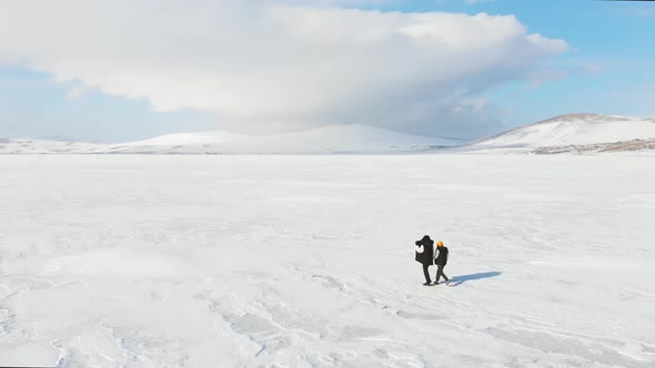 Woman With Boy On Frozen Lake Enjoys Winter Landscpe