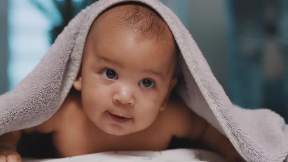 Close Up of Cute Black Baby with Head Covered with Fluffy Towel