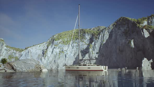 White Yacht Anchored in a Bay with Rocky Cliffs