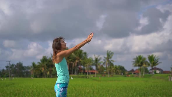 Slowmotion Shot of a Young Woman Practicing Yoga on a Beautiful Rice Field