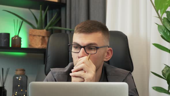 Man is sitting in office, looking away, thinking of inspiration, searching problem solution at work