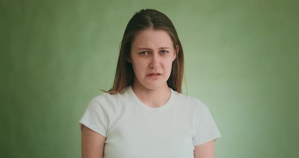 Young Woman Cries with Offence Posing for Camera on Green
