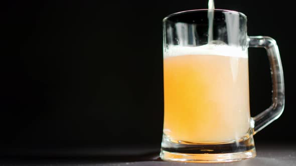 Low Angle Fresh Appetizing Yellow Malt Beverage Pouring From Top Into Big Mug