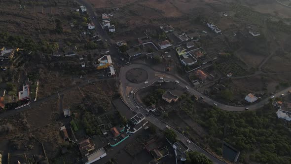 Roundabout in Portuguese village covered with volcanic ash on La Palma island. Aerial top-down circl