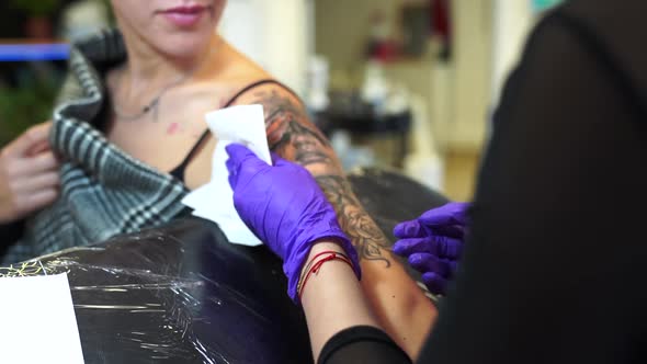 Tattoo artist tattooing an arm