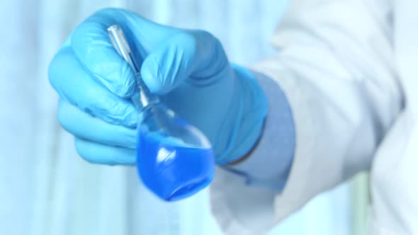 Hand of Scientist Holding Lab Glassware Close Up 