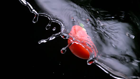 Slo-motion tomato wedges mixing with water