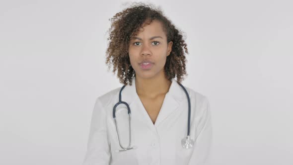 Thumbs Down Gesture By African Female Doctor on White Background