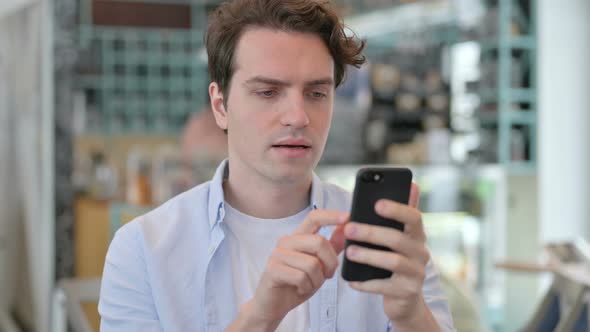 Portrait of Young Man Celebrating on Smartphone