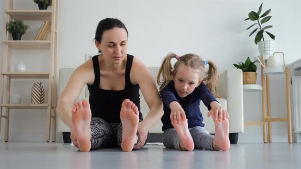 Little Girl with Mother Doing Fitness Exercises