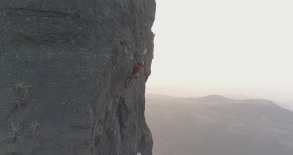 Cinematic drone shot of rock climbers climbing a multi pitch sports route on a basalt rock pinnacle