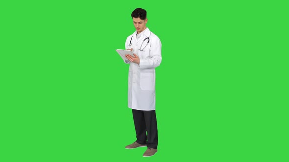 Doctor Holding Digital Tablet Pc and Reading Results on a Green Screen, Chroma Key.