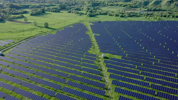 Aerial view on Solar Power Station in Green Field near River at Sunny Day
